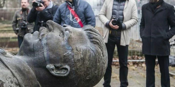 Para jurnalis menyaksikan saat patung diktator Uni Soviet Joseph Stalin setinggi 4,8 meter diangkat dengan menggunakan crane di Karl-Marx Allee, Berlin pada 23 Januari 2018. Patung ini berdiri selama 15 menit sebelum dipindahkan setelah digunakan sebaga alat promosi sebuah eksebisi soal Stalin bertajuk Stalin, Sang Tuhan Merah. (AFP/JOHN MACDOUGALL)