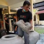 Pegawai Museum Bagawanta Bhari membersihkan koleksi benda bersejarah setelah aksi penjarahan, di Kediri, Jawa