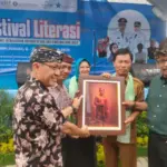 Kepala Bidang Perlindungan dan Penyelamatan Arsip Cecep Supriadi menyerahkan cinderamata beruopa lukisan tokoh