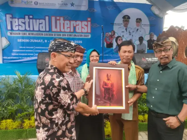 Kepala Bidang Perlindungan dan Penyelamatan Arsip Cecep Supriadi menyerahkan cinderamata beruopa lukisan tokoh